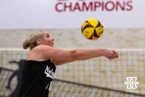 Nebraska Cornhusker Kenna Cogill (11) digs the ball against the Ottawa Braves during a college beach volleyball match on Monday, Feb. 23, 2026, in Lincoln, NE. Photo by John S. Peterson.