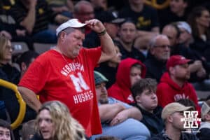 Nebraska Cornhusker fan adjusts his hat watching the action against the Iowa Hawkeyes in the first half during a college basketball game on Tuesday, Feb. 17, 2026, in Iowa City, Iowa. Photo by John S. Peterson.
