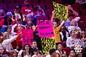 Nebraska Cornhuskers and Iowa Hawkeyes fans holding up signs during a college basketball game on Monday, Feb. 16, 2026, in Lincoln, Nebraska. Photo by John S. Peterson.