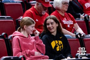Nebraska Cornhusker fan and Iowa Hawkeye fan watching the game together during a college basketball game on Monday, Feb. 16, 2026, in Lincoln, Nebraska. Photo by John S. Peterson.