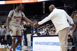 Omaha Maverick Valentino Simon (21) high fives head coach Chris Crutchfield during a college basketball game against St. Thomas on Feb 12, 2026, in Omaha, Nebraska. Photo by Brandon Tiedemann