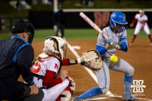 A UCLA Bruin watches as a pitch crosses over the plate behind her during a college softball game against Nebraska, Mar. 27, 2026, Lincoln, Nebraska. Photo by Braden Cochran.