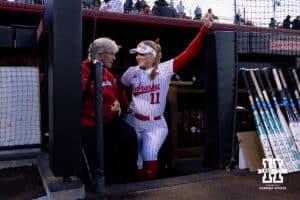 Nebraska outfielder Talia Tokenheim (11) talks with head coach Rhonda Revelle in the dugout during a college softball game against UCLA Mar. 27, 2026, Lincoln, Nebraska. Photo by Braden Cochran.