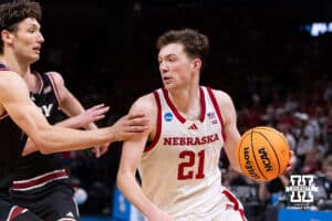 Nebraska Cornhusker forward Pryce Sandfort (21) dribbles into Troy Trojan forward Thomas Dowd (1) in the seocnd half during the first round of the NCAA Men’s Basketball Championship on Thursday, March 19, 2026, in Oklahoma City. Photo by John S. Peterson.