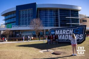 Nebraska Cornhusker fans have a photo taken in front of the March Madness sign during the first round of the NCAA Men’s Basketball Championship on Thursday, March 19, 2026, in Oklahoma City. Photo by John S. Peterson.