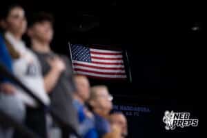Fans stand for national anthem with flag during a Boys State Championship First Round basketball game Thursday, March 12, 2026, in Lincoln, Nebraska. Photo by Jackson D. Luethje.