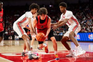 Lincoln High's Deveraux Sanders (3) dribbles through London Dada (11) Darien Jenkins (21) during a Boys State Championship First Round basketball game Wednesday, March 11, 2026, in Lincoln, Nebraska. Photo by Jackson D. Luethje.