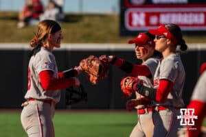 Nebraska Cornhuskers Jordy Frahm, Ava Kuszak, and Lauren Camenzind celebrate during a softball game at Bowlin Field on March 7th, 2026, in Lincoln, Nebraska. Photo by Collin Stilen.