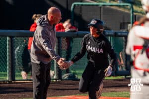 Omaha Maverick Marra Cramer high-fives head coach Mike Heard after she scores a home run during a softball game at Bowlin Field on March 7th, 2026, in Lincoln, Nebraska. Photo by Collin Stilen.