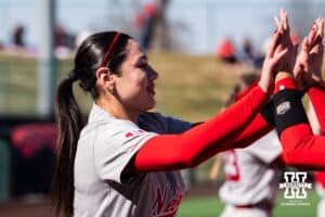 Nebraska Cornhusker Bella Bacon gives high fives to teammates pregame during a softball game at Bowlin Field on March 7th, 2026, in Lincoln, Nebraska. Photo by Collin Stilen.