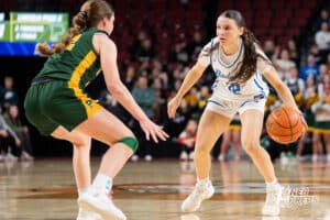 Bennington's Harper Bohaboj (12) guarded by Lincoln Pius X's Kate Miller (42) during a Girls State Championship Semifinal Round basketball game Friday, March 6, 2026, in Omaha, Nebraska. Photo by Jackson D. Luethje.