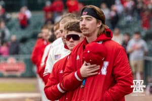 Nebraska Cornhusker pitcher Pryce Bender (6) holding his hat over his heart for the National Anthem before taking on the Michigan State Spartans during a college baseball game on Friday, March 6, 2026, in Lincoln, Nebraska. Photo by John S. Peterson.