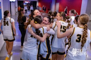 Gretna East’s Jada Freeland (5), Taryn French (13), and Maggie Pfaff (11) are sharing a hug after winning a high school state basketball game against Sidney on March 4, 2026 in Lincoln, Nebraska. Photo By Jack Stephens.