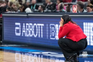 Nebraska Cornhusker head coach Amy Williams squats on the sideline during a college basketball game against Indiana on Mar 4th, 2026, in Indianapolis, Indiana. Photo by Brandon Tiedemann