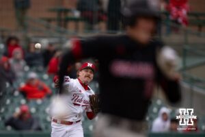 Nebraska Cornhusker pitcher Cooper Katskee (19) tries to throw Omaha Maverick Jackson Trout (20) out at first during a college baseball game on Tuesday, March 3, 2026, in Lincoln, Nebraska. Photo by John S. Peterson.