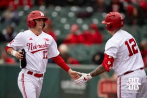 Nebraska Cornhusker outfielder Mac Moyer (17) gets five from Cole Kitchens (12) after scoring a run against the Omaha Mavericks in the first inning during a college baseball game on Tuesday, March 3, 2026, in Lincoln, Nebraska. Photo by John S. Peterson.