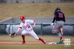 Omaha Maverick utility Jackson Trout (20) beats the ball to first against Nebraska Cornhusker infielder Case Sanderson (14) in the first inning during a college baseball game on Tuesday, March 3, 2026, in Lincoln, Nebraska. Photo by John S. Peterson.