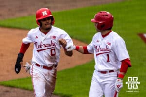 Nebraska Cornhusker Jeter Worthley (0) gives Jett Buck a fist bump after scoring a run against the Kansas State Wildcats in the third inning during a college baseball game at Haymarket Park on Tuesday, April 28, 2026, in Lincoln, Neb. Photo by John S. Peterson.