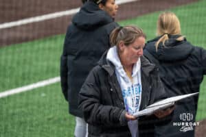 Creighton Bluejays head coach Krista Wood looks at her book during a college softball game on April 28, 2026, in Omaha, Nebraska. Photo by Brandon Tiedemann.