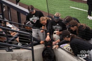 Omaha Mavericks pet a dog before a college softball game against Creighton on April 28, 2026, in Omaha, Nebraska. Photo by Brandon Tiedemann.