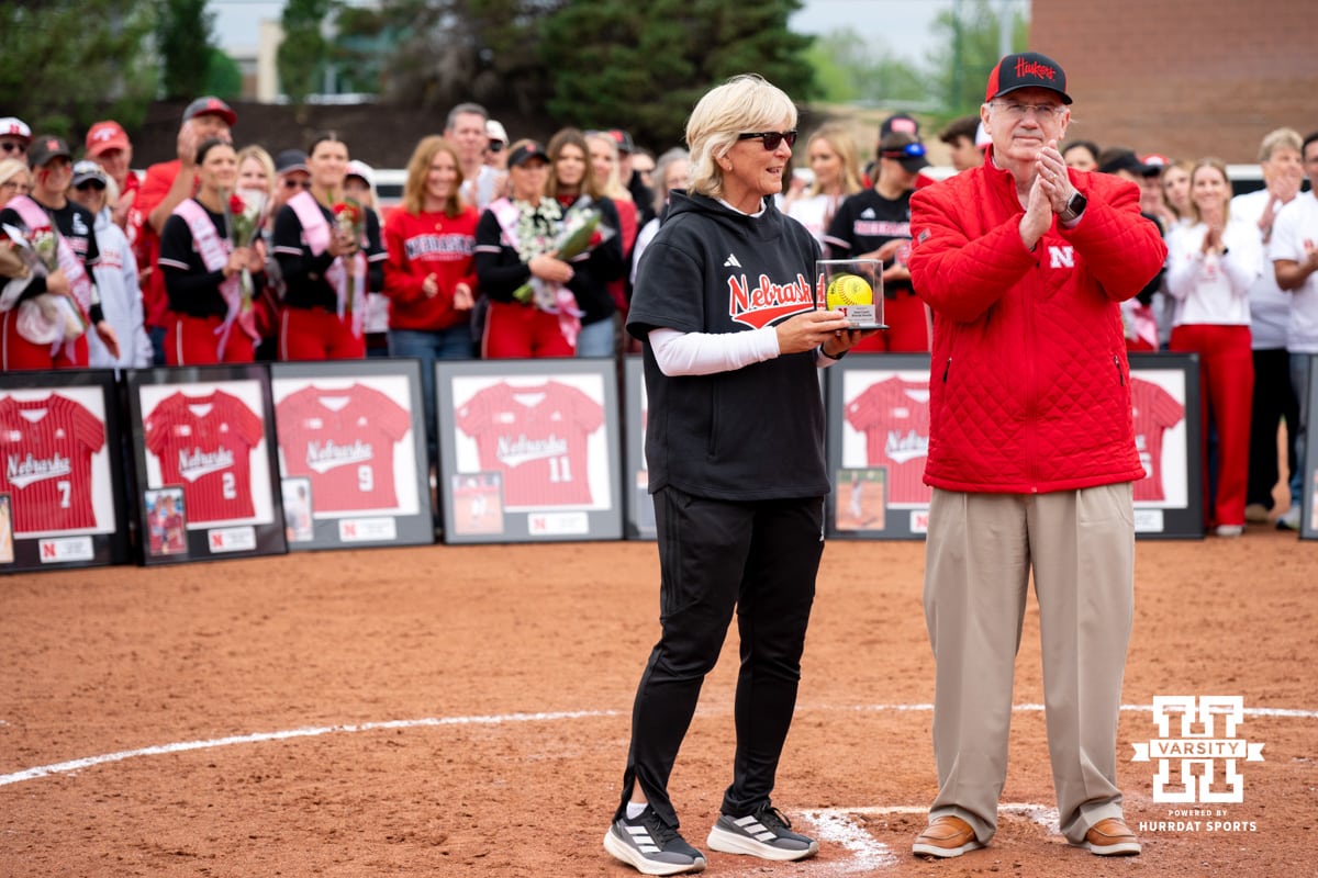 Nebraska head coach Rhonda Revelle is handed a game ball from a few weeks past where she hit a milestone of 1200 career wins with the Huskers during a college softball game, Apr. 25, 2026, Lincoln, Nebraska. Photo by Braden Cochran.