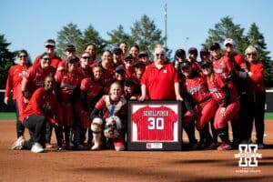 Nebraska softball players pose for a pitcher with past player Kim Schellpeper before the game during a college women’s softball game, Apr. 24, 2026, Lincoln, Nebraska. Photo by Braden Cochran.