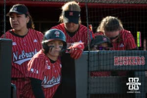 A Nebraska Cornhusker watches from the dugout as her teammate bats during a college women’s softball game, Apr. 24, 2026, Lincoln, Nebraska. Photo by Braden Cochran.