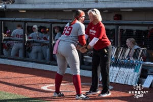 Nebraska Cornhusker head coach Rhonda Revelle and Alexis Jensen (99) shake hands before a college softball game against Omaha on April 21, 2026, in Omaha, Nebraska. Photo by Brandon Tiedemann