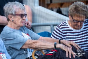 Omaha Softball legend Connie Claussen sits during a college softball game against Omaha or Nebraska on April 21, 2026, in Omaha, Nebraska. Photo by Brandon Tiedemann