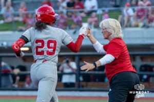 Nebraska Cornhusker Samantha Bland (29) fist bumps head coach Rhonda Revelle during a college softball game against Omaha on April 21, 2026, in Omaha, Nebraska. Photo by Brandon Tiedemann