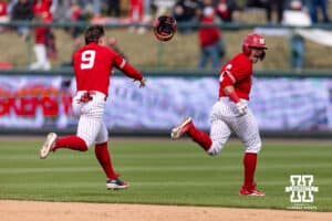 Nebraska Cornhusker infielder Rhett Stokes (9) throws his batting helmet at Trey Fikes after he brought him home in during a college baseball game on Saturday, April 18, 2026, in Lincoln, Neb. Photo by John S. Peterson.