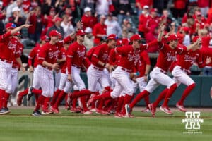 Nebraska Cornhuskers come out of the dugout to chase Trey Fikes after he hit a two-run single to win the game with a run-rule in the seventh inning during a college baseball game on Saturday, April 18, 2026, in Lincoln, Neb. Photo by John S. Peterson.