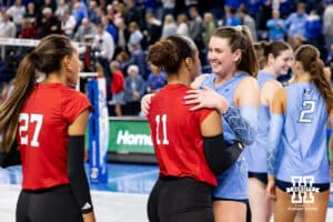 Nebraska Cornhusker outside hitter Teraya Sigler (11) and Creighton Bluejay middle blocker Ayden Ames (5) hug after a college volleyball match on Friday, April 17, 2026, in Omaha, Neb. Photo by John S. Peterson.