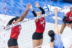 Nebraska Cornhusker middle blockers Kenna Cogill (8) and Jayden Robinson jump to block Creighton Bluejay outside hitter Destiny Ndam-Simpson (18) in the fourth set during a college volleyball match on Friday, April 17, 2026, in Omaha, Neb. Photo by John S. Peterson.