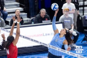 Creighton Bluejay rs/mb Jaya Johnson (6) tips the ball against Nebraska Cornhusker middle blocker Manaia Ogbechie (14) in the third set during a college volleyball match on Friday, April 17, 2026, in Omaha, Neb. Photo by John S. Peterson.