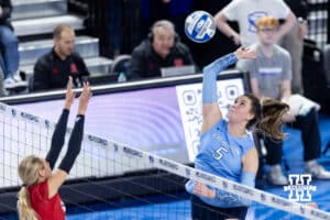Creighton Bluejay middle blocker Ayden Ames (5) spikes the ball against Nebraska Cornhusker outside hitter Gabby DiVita (23) in the third set during a college volleyball match on Friday, April 17, 2026, in Omaha, Neb. Photo by John S. Peterson.