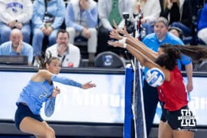 Creighton Bluejay outside hitter Abbey Hayes (2) spikes the ball against Nebraska Cornhuskers Teraya Sigler (11) and Virginia Adriano (3) in the second set during a college volleyball match on Friday, April 17, 2026, in Omaha, Neb. Photo by John S. Peterson.