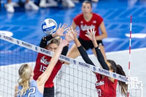 Creighton Bluejay right side hitter Ashlyn Paymal (22) spikes the ball against Nebraska Cornhuskers Andi Jackson (15) and Harper Murray (27) in the second set during a college volleyball match on Friday, April 17, 2026, in Omaha, Neb. Photo by John S. Peterson.