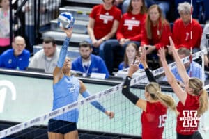 Creighton Bluejay outside hitter Abbey Hayes (2) hits the ball against Nebraska Cornhusker middle blocker Andi Jackson (15) and Campbell Flynn (4) in the second set during a college volleyball match on Friday, April 17, 2026, in Omaha, Neb. Photo by John S. Peterson.