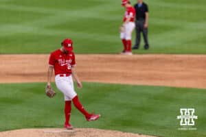 Nebraska Cornhusker pitcher Caleb Clark (24) cleans up the mound before pitching against the Creighton Bluejays during a college baseball game on Tuesday, April 14, 2026, in Lincoln, Neb. Photo by John S. Peterson.