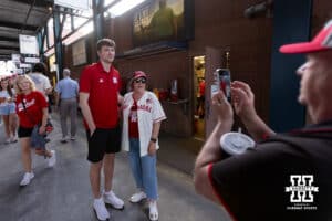 Nebraska Cornhusker basketball player Pryce Sandfort poses for a photo with a fan during a college baseball game against the Creighton Bluejays on Tuesday, April 14, 2026, in Lincoln, Neb. Photo by John S. Peterson.