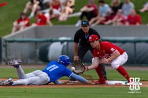 Creighton Bluejay Ben North (11) dives back to first against Nebraska Cornhusker infielder Case Sanderson (14) in the first inning during a college baseball game on Tuesday, April 14, 2026, in Lincoln, Neb. Photo by John S. Peterson.