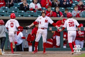 Nebraska Cornhusker infielder Josh Overbeek (4) gives Jeter Worthley and Miken Miller five after Worthley scored a run in the fifth against the Kansas Jayhawks during a college baseball game on Tuesday, April 7, 2026, in Lincoln. Photo by John S. Peterson.