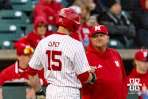 Nebraska Cornhusker head coach Will Bolt gives Dylan Carey a fist bump against the Kansas Jayhawks in the fifth during a college baseball game on Tuesday, April 7, 2026, in Lincoln. Photo by John S. Peterson.