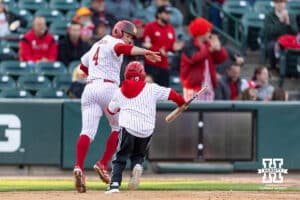 Nebraska Cornhusker Josh Overbeek (4) runs to the dugout with the batboy after scoring a run in the second inning against the Kansas Jayhawks during a college baseball game on Tuesday, April 7, 2026, in Lincoln. Photo by John S. Peterson.