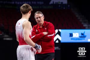 Nebraska Cornhusker Nathan York talks with head coach Chuck Chmelka warming up during the Big Ten Men's Gymnastics Team Championship on Friday, April 3, 2026, in Lincoln. Photo by John S. Peterson.