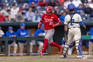 Nebraska Cornhusker outfielder Drew Grego (10) scores a run against Creighton Bluejay catcher Connor Capece (2) in the second inning during a college baseball game on Tuesday, March 31, 2026, in Omaha. Photo by John S. Peterson.
