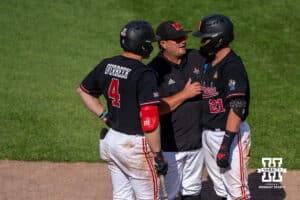 Nebraska Cornhusker head coach WIll Bolt talks with Joshua Overbeek (4) and Trey Fikes (21) during a regional baseball game against Arizona State on May 31, 2026, in Lincoln, Nebraska. Photo by Brandon Tiedemann.