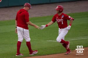 Nebraska Cornhusker Jett Buck (1) high fives his coach during a regional baseball game against Ole Miss on May 30, 2026, in Lincoln, Nebraska. Photo by Brandon Tiedemann.