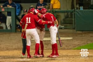 Nebraska Cornhuskers huddle at the plate during a regional baseball game against Ole Miss on May 30, 2026, in Lincoln, Nebraska. Photo by Brandon Tiedemann.
